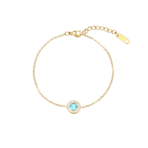 Close-up of gold stainless steel bracelet with a light blue stone and crystal halo