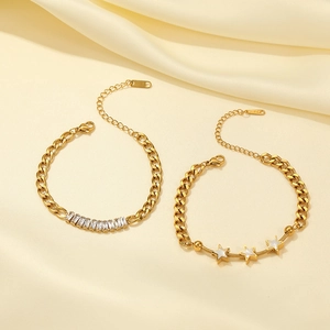 Elegantes Gold-Titanstahl-Sternarmband-Set mit Zirkoniasteinen auf Seidenhintergrund