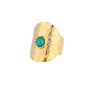 Macro detail of golden bohemian ring with round turquoise stone and leaf engraving