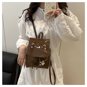 Gros plan du mini sac à dos marron brillant avec motif chat et fermeture à cordon