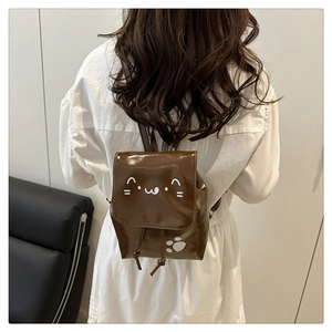 Détail d'un mini sac à dos marron brillant avec visage de chat mignon et pattes