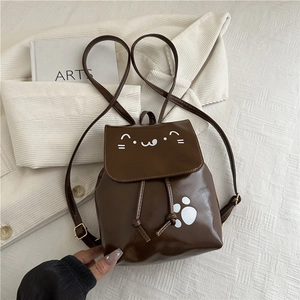 Détail du petit sac à dos marron en cuir synthétique avec motifs chat et pattes