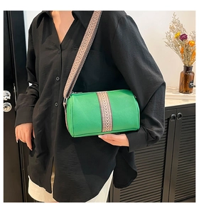 Detail of green cylinder leather crossbody bag with ethnic geometric pattern strap