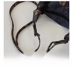 Close-up of adjustable strap with black resin buckle on vintage floral print crossbody bag