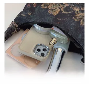Internal capacity of moon-shaped handbag showing phone, perfume and cosmetics storage