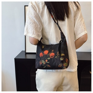 Floral pattern crossbody bag with orange fruit motifs and adjustable black shoulder strap