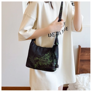 Dettaglio della borsa a mezzaluna regolabile con motivi floreali jacquard verdi