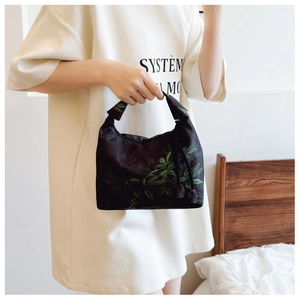 Detail of Xiangyun silk crescent bag with green leaf print and tassel decoration