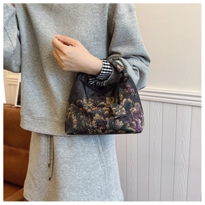 Detail of vintage floral print handbag with drawstring and circular ornament