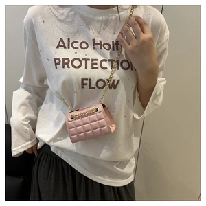 Pink quilted mini chain bag shown as crossbody style on model to demonstrate size