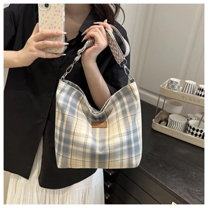 Detailed view of the checkered canvas tote with blue and white pattern and leather tag