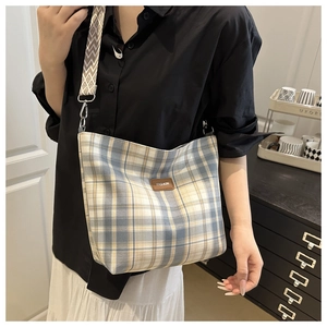 Detail of plaid canvas tote with FASHION leather patch and patterned wide strap