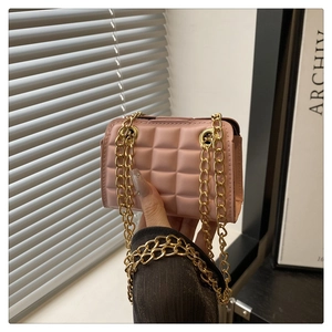 Detailed view of pink quilted checkerboard pattern bag with golden chain strap
