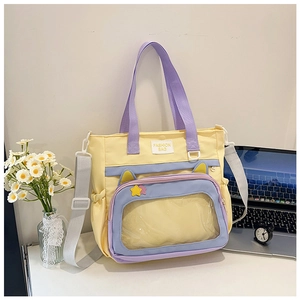 Detail of yellow cat-eared canvas bag featuring a clear PVC pocket and colorful straps