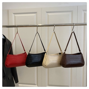 Detail of crocodile pattern shoulder bags in red, black, beige, and coffee brown colors
