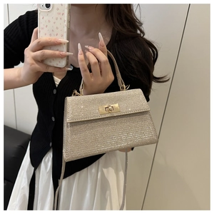 Close-up of glitter trapezoid handbag with gold metal twist lock and sequin texture
