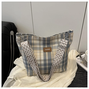 Close-up of blue and yellow plaid canvas tote with a retro geometric wide strap