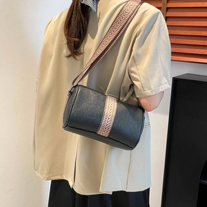 Sac cylindre noir en cuir grainé avec large bandoulière géométrique rétro pour femme
