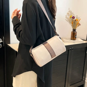 Sac cylindrique en cuir blanc texturé avec large bandoulière à motifs sur modèle