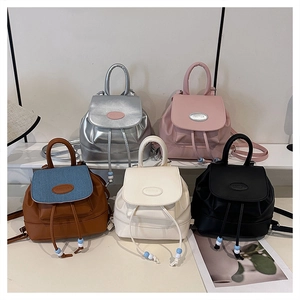 Multiple mini PU leather backpacks in silver, pink, blue, white, and black colors