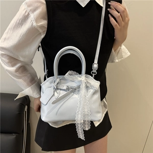 Sac à main en cuir verni bleu clair avec nœud en dentelle et bandoulière de forme trapèze
