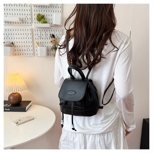 Close-up of mini black drawstring backpack with magnetic flap and bead detail
