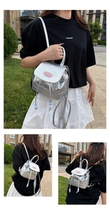 Detail of silver metallic mini backpack with pink logo and beaded drawstring tassels