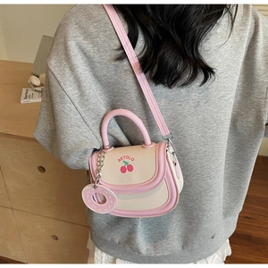 Detail of sweet cherry print bag with donut charm and pink adjustable shoulder strap
