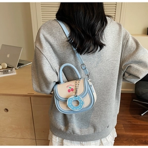 Details der hellblauen Satteltasche mit Kirschprint und Donut-Anhänger