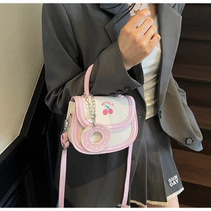 Details der rosa-weißen Satteltasche mit Kirschmuster und süßem Donut-Anhänger