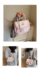 Nahaufnahme der rosa Mini-Tasche mit Kirschmuster und süßem Donut-Anhänger