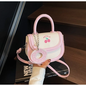 Detail der rosa-beigen Mini-Satteltasche mit Kirschprint und Donut-Anhänger