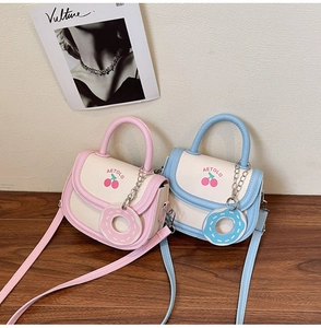 Detail of candy-colored mini saddle bags with cherry print and donut pendants on wood