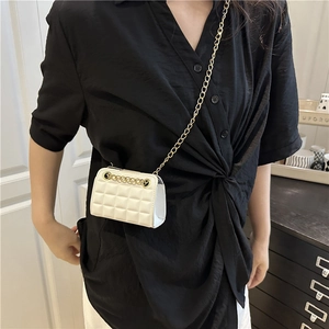Chic white quilted mini crossbody bag with gold chain strap worn by a model in black