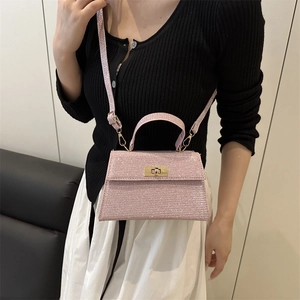 Pink shimmering glitter handbag with golden turn-lock in a stylish crossbody style