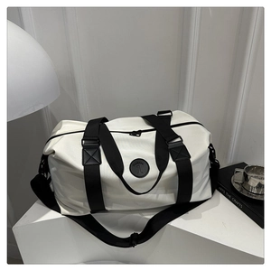 Close-up of black leather patch with fashion logo on white oxford travel bag