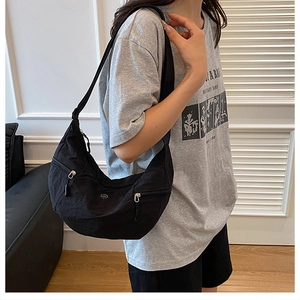 Dettaglio della borsa a tracolla a mezzaluna in nylon nero con tasca a zip