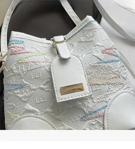 Detail of white bucket bag featuring colorful wave stitching and embossed texture