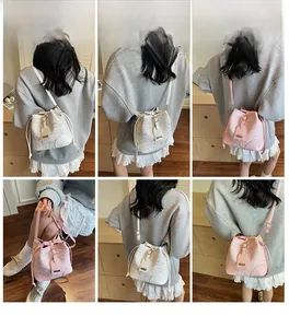 Dettagli delle borse a secchiello con coulisse in bianco e rosa con texture a rilievo