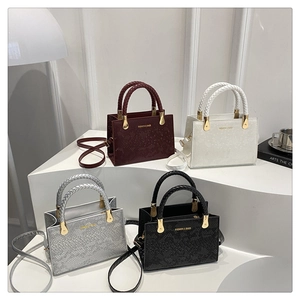 Details von vier Schlangenhaut-Handtaschen mit gewebten Griffen und goldenen Beschlägen