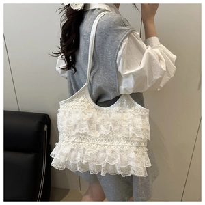 Detail of white lace layered ruffle tote bag featuring intricate floral crochet texture