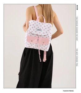 Detail of floral canvas backpack with pink pockets shown on model for size perspective