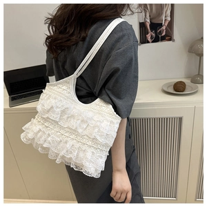 Detailed view of white lace tote bag with delicate layered ruffles and slim shoulder straps