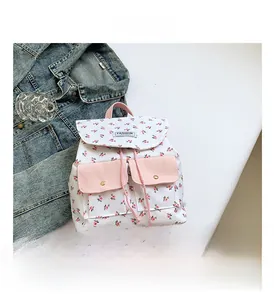 Detail of floral backpack showing drawstring closure, front pockets and metal buckles