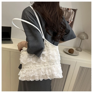 Detailed close-up of white layered lace stitching and soft texture on the tote bag