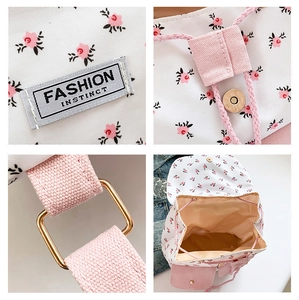 Detail view of floral canvas backpack with drawstring closure and metal buckles