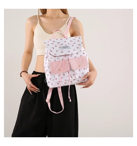 Detailed view of women's floral canvas backpack with dual front pockets and drawstring