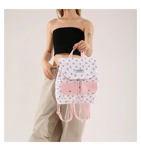 Close-up of floral canvas backpack featuring pink snap pockets and fashion label