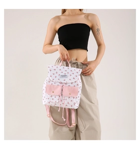 Detail of pink floral canvas backpack with metal buckles and drawstring closure