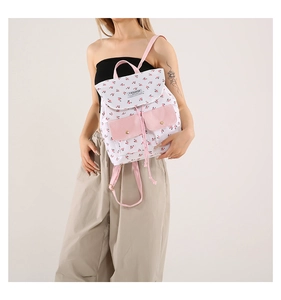 Detailed view of floral canvas backpack with pink corduroy pockets and drawstring